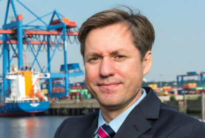 Das Foto zeigt Professor Carlos Jahn vor Kränen im Hafen.